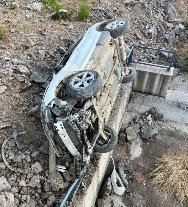Ağaca çarpma sonucu ön kısmı ezilmiş siyah otomobil